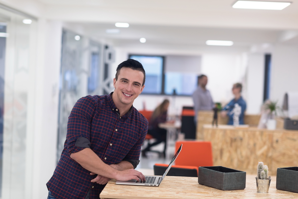 portrait of young businessman in casual clothes at modern  startup business office space,  working on laptop  computer